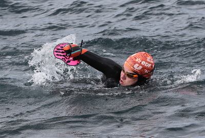 El francés Théo Curin, nadador y medallista paralímpico, con la prótesis empleada para nadar en las aguas del lago Titicaca, junto a dos compatriotas más.