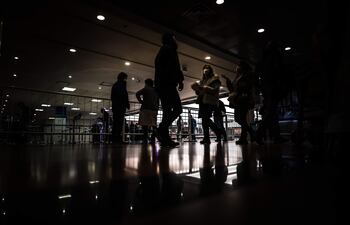Personas con tapabocas caminan en el Aeropuerto Internacional de Ezeiza, en Buenos Aires.