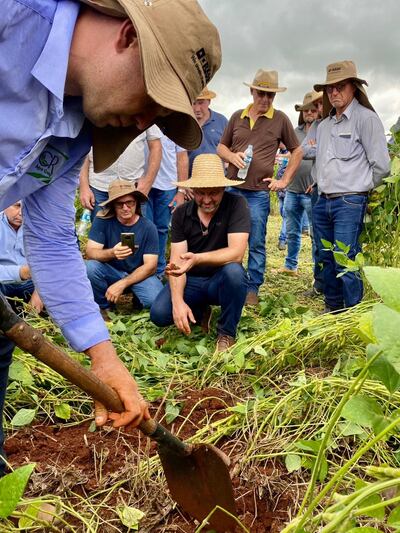 Laercio Dalla Vecchia (sombrero) observa como Cleandro Rossetti remueve la arena en un campo de soja. El campeón brasilero en productividad de soja compartió su experiencia con productores.