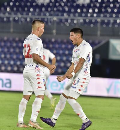 Alan Goméz celebra junto a Rodrigo Vera el tanto del descuento en el juego ante Libertad.