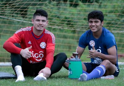 Alfredo Aguilar y Robert Rojas se refrescan con tereré en la selección nacional.