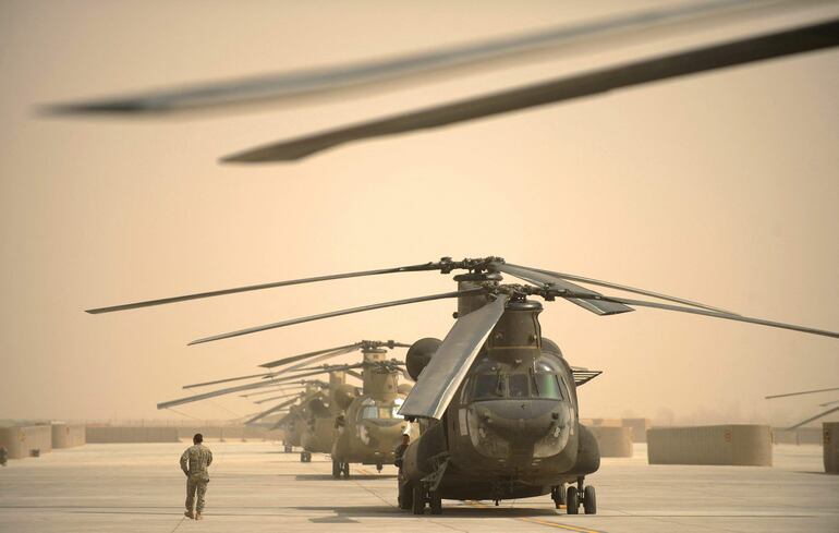 Un soldado estadounidense camina junto a una hilera de helicópteros Chinook en una base aéra en Kandahar, Afganistán, en marzo de 2011.