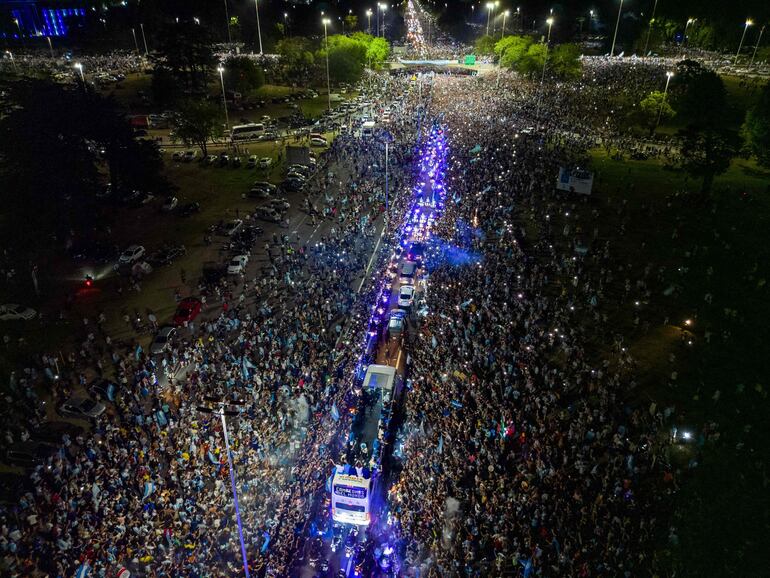 Los jugadores de la selección de Argentina a bordo del bus descapotable durante el recorrido hasta el predio de Ezeiza en compañía de miles y miles de argentinos, que recibieron al plantel en el Aeropuerto Internacional de Ezeiza después de la conquista del Mundial Qatar 2022. 
