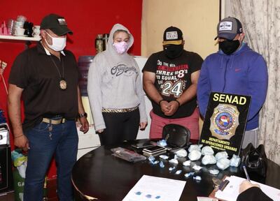 Un agente de la Senad custodia a  Ruth Fabiana Musstto, Miguel Hipólito Alcaraz y Julio González Noguera, con la cocaína.