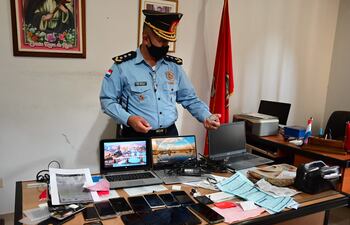 El jefe de la comisaría 11° de Asunción, comisario principal José Santacruz verifica uno de los documentos encontrados en poder de los detenidos.