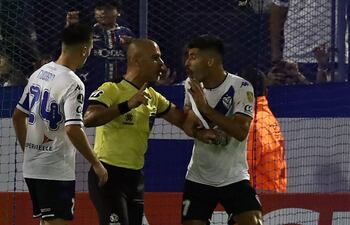 El árbitro paraguayo Éber Aquino discute con José Florentín, jugador de Vélez, quien fue expulsado por un choque involuntario contra el arquero de Nacional de Uruguay.