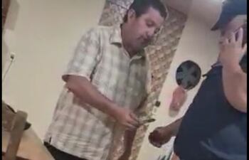 El policía cuando iba a recibir el dinero en la subcomisaría 14ª de Minga Guazú. (captura de vídeo).