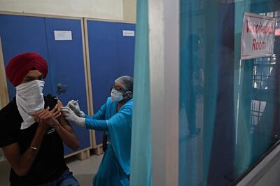 Un enfermero inocula a un hombre con una dosis de la vacuna Covishield contra el coronavirus en Jind, India.