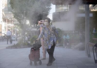 Transeúntes caminan bajo un rociador de niebla en el centro de Tokio, Japón, el 01 de julio de 2022.