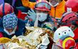 Elif Perincek, una niña de tres años, agarra el pulgar de uno de los recatistas que la liberó de entre los escombros de un edificio que colapsó durante el terremoto en Izmir, Turquía.