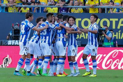 Los jugadores Del Real Sociedad celebran el primer gol marcado por el centrocampista del Real Sociedad, Take Kubo (2d), durante el partido de LaLiga Santander que enfrenta al Cádiz CF y al Real Sociedad en el estadio Nuevo Mirandilla, Cádiz, este domingo.