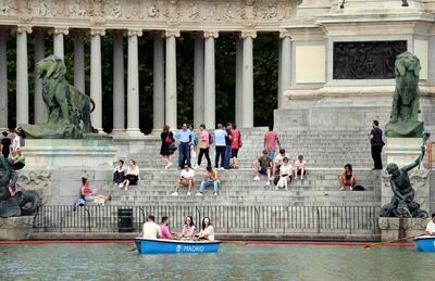 En Madrid, la gente busca el fresco aproximándose a la laguna en el Parque del Retiro.