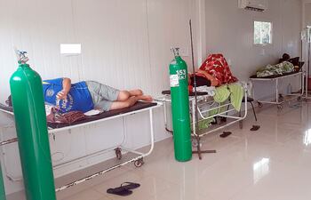 Pacientes con balones de oxígeno son atendidos en los pasillos.