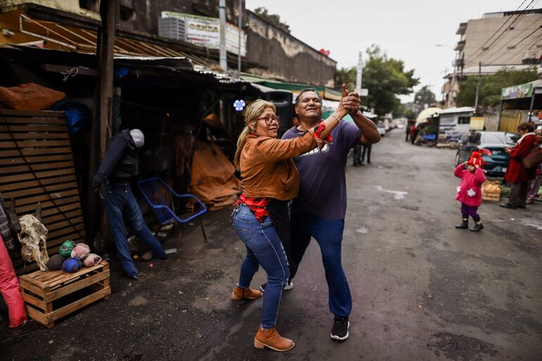 Vendedores bailan música paraguaya en el marco de la fiesta de San Juan, hoy, en el Mercado 4 en Asunción (Paraguay). 
