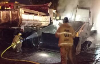 Bomberos tratando de salvar el camión volquete que comenzó a incendiarse