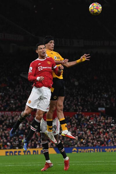 El mexicano Raúl Jiménez supera en el salto al portugués Cristiano Ronaldo, durante el partido que Wolverhampton venció ayer 1-0 al Manchester United.