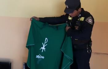 Un policía de la comisaría 11° sostiene la casulla recuperada entre los objetos hurtados.