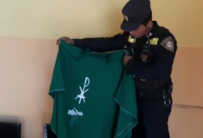 Un policía de la comisaría 11° sostiene la casulla recuperada entre los objetos hurtados.