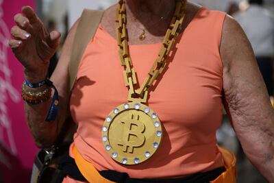 Con un enorme collar, una asistente a la conferencia Bitcoin 2021 pasea por la sede del evento.
