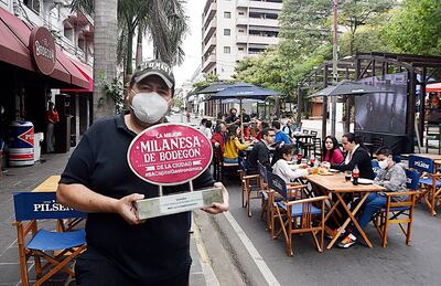 Christian Franco muestra su premio   en su restaurante repleto que finalmente se salvó de cerrar.