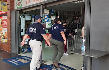 Agentes policiales ingresando al Supermercado La Familia de Encarnación.