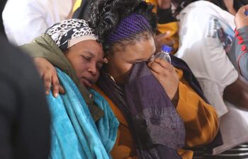 Familiares lloran ante los ataúdes de las 21 jóvenes víctimas que fallecieron tras una fiesta extraescolar en Enyobeni Tavern, Sudáfrica.