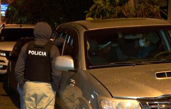 Agentes de la SIU conversa con el detenido, quien ya esta sentado en el asiento posterior de la camioneta de la Policía, en el barrio Santa María, Zona Norte de Fernando de la Mora.