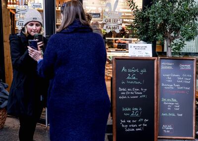 La anfitriona de un restaurant chequea que una cliente cuente con el certificado de vacunación contra el COVID-19, para dejarla ingresar al recinto, en Berlín, Alemania.