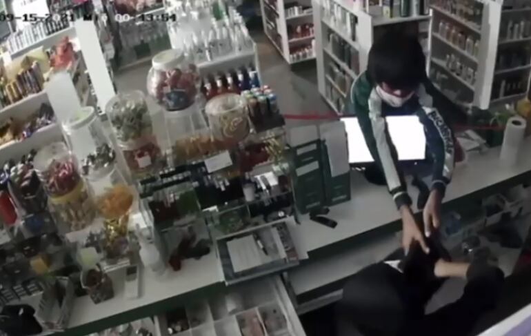 Dos de los pequeños se encargan de vaciar la caja registradora del local.