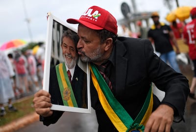 Un partidario besa un retrato del presidente electo Luiz Inacio Lula da Silva afuera del hotel donde se hospeda Lula en Brasilia.