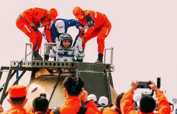 El astronauta chino Ye Guangfu (C) es asistido por funcionarios para salir de la cápsula de la nave espacial Shenzhou-13 después de aterrizar en Mongolia Interior de China el 16 de abril de 2022.