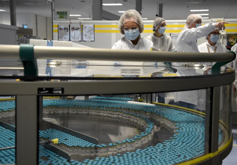 (FILES) In this file photo taken on December 03, 2020, an employee works on a production line at the factory of British multinational pharmaceutical company GlaxoSmithKline (GSK) in Saint-Amand-les-Eaux, northern France. - The World Health Organization warned that vaccines were no magic bullet for the coronavirus crisis, as Russia started vaccinating its high-risk workers Saturday and other countries geared up for similar programmes. (Photo by FRANCOIS LO PRESTI / AFP)