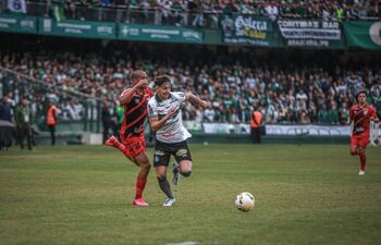 Matías Galarza (d), del Coritiba, se escapa de la marca del defensor de Athletico Paranaense.