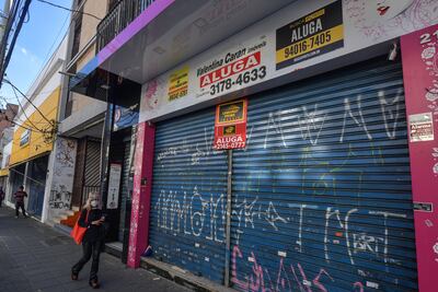 Una mujer pasa por una tienda vacía para alquilar en una zona comercial de Sao Paulo, Brasil.