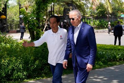US President Joe Biden (R) greets Indonesia's President Joko Widodo as he arrives for a tree planting event at the Taman Hutan Raya Ngurah Rai Mangrove Forest, on the sidelines of the G20 summit meeting in Nusa Dua, on the Indonesian resort island of Bali on November 16, 2022. (Photo by Alex Brandon / POOL / AFP)