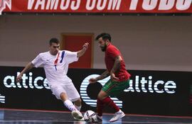 Javier Salas disputa el balón contra un portugués, en el primer amistoso de la selección paraguaya de futsal, en el país luso.