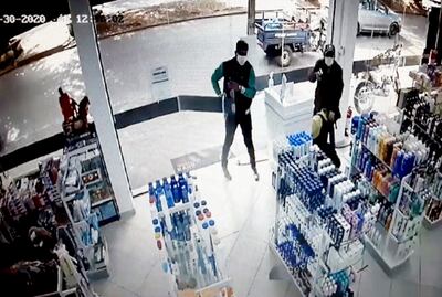 Las cámaras  de seguridad  captaron el momento en que ambos criminales entran a la farmacia e intenta reducir al guardia.