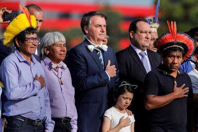 En esta foto de archivo, el presidente de Brasil, Jair Bolsonaro posa con personas indígenas. Ahora su gobierno autorizó el despliegue de fuerzas de seguridad en la reserva de Yanomami.