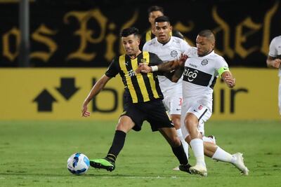Pablo Daniel Ceppelini (i) de Peñarol disputa el balón con Richard Ortiz de Olimpia hoy, en un partido de la Copa Libertadores entre Peñarol y Olimpia en el estadio Centenario en Montevideo (Uruguay).