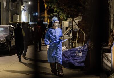Una persona vistiendo un traje de protección biológica en una zona en cuarentena en Shanghai, China, este sábado.