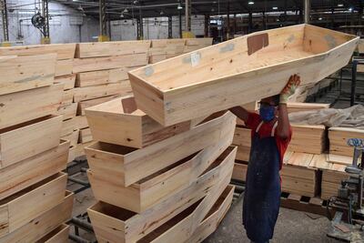 Un empleado trabaja en la fabricación de ataúdes en la Fábrica de Urnas Funerarias Bignotto, en Cordeiropolis, estado de Sao Paulo, Brasil, el 19 de mayo de 2020, en medio de la nueva pandemia de coronavirus.