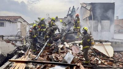 Rescatistas y bomberos trabajan en uno de los edificios dañados tras el impacto de una avioneta particular, en Medellín, Colombia.