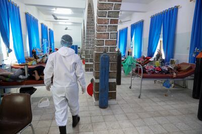 Un miembro yemení del personal médico camina en la sala de pacientes en un centro de cuarentena donde los pacientes con COVID-19 son tratados, en la tercera ciudad de Taez, Yemen.