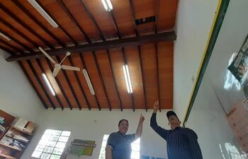 La profesora Ester Velázquez y el padre de familia, Don Basilio Velásquez, mostrando parte de un techo caído de la institución.