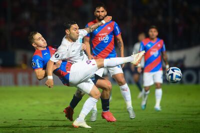 Robert Piris Da Motta (i), futbolista de Cerro Porteño, disputa un balón con Carmelo Algarañaz (c), jugador de Bolívar, en el partido de la fase de grupos de la Copa Libertadores en el estadio General Pablo Rojas, en Asunción, Paraguay.