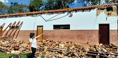 La docente, Ana Añasco, mostrando el pabellón derrumbado.