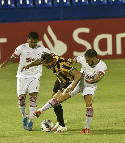 Ursino y Justiniano salen a buscar la pelota que se lleva el delantero aurinegro Raúl Bobadilla.
