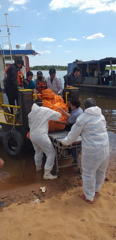 Momento en que los intervinientes trasladan el cuerpo de Francisco Javier Pérez a la costa del Río Paraguay para la inspección correspondiente.