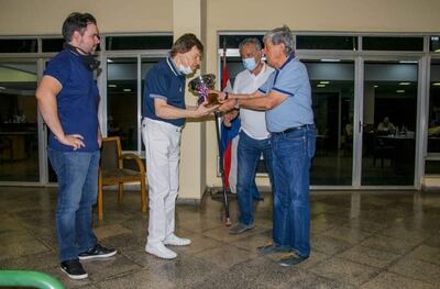 Roberto Antebi, dueño de Líbero, recibe la copa “Clausura” de manos del titular del Jockey Club, Gustavo Pedrozo, tras la victoria del pingo en la carrera sobre 1.800 metros.