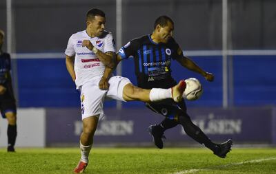 El experimentado capitán del 12 de Octubre, Paulo da Silva, marca fuete al goleador de Nacional, Leonardo Villagra.